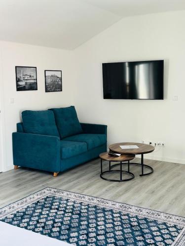 a living room with a blue couch and a table at Bella Casa Bed and Breakfast in Ponta Delgada
