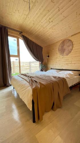 a large bed in a room with a large window at Экохаус Бурабай 1 in Borovoye
