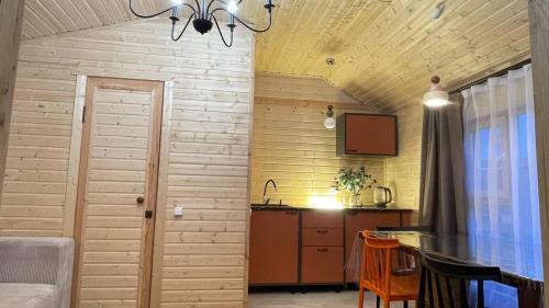 a living room with a table and a kitchen at Экохаус Бурабай 1 in Borovoye