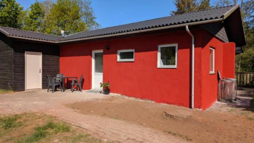 a red house with a table in front of it at Daemningen at Gammel Rye in Ry