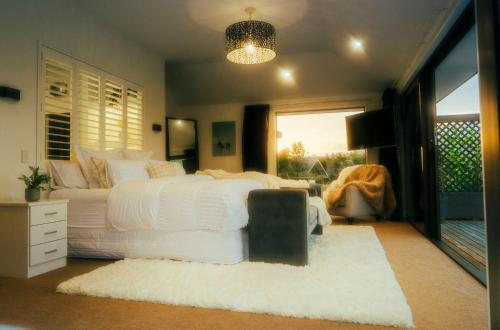 a bedroom with a white bed and a window at Kilmarnock House in Dunedin