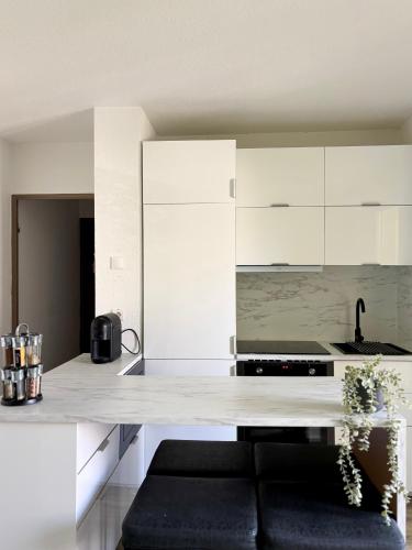 une cuisine avec des armoires blanches et un comptoir dans l'établissement Appartement T3 Avignon, proche centre-ville, à Avignon