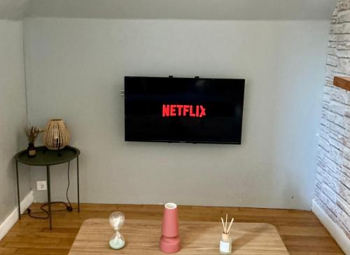 a television on a wall with the wordnetflix on it at T2 dans le quartier Saint-Michel de Saint Brieuc Vue sur les toits in Saint-Brieuc