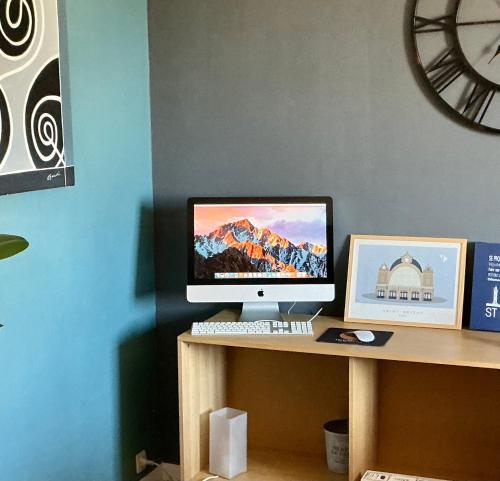 a computer monitor sitting on a desk with a picture at T2 dans le quartier Saint-Michel de Saint Brieuc Vue sur les toits in Saint-Brieuc