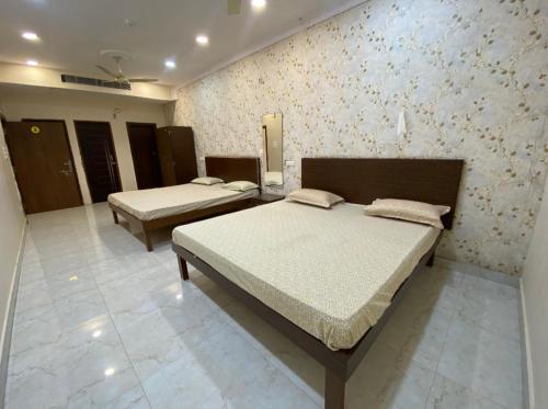 a bedroom with two beds and a wall at The Eklavya Resort in Rānchī