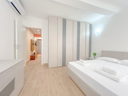 a white bedroom with a large bed and a hallway at Designer Suite - Luxury - Via Sestri - Free WiFi in Genova