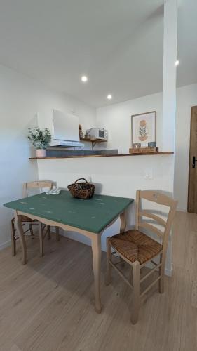a table and chairs in a room with a kitchen at Appartement cosy avec jardin in Meauzac