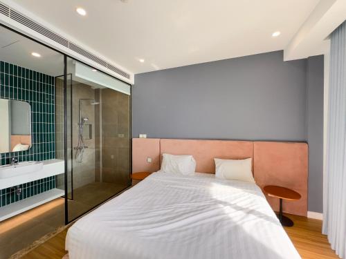 a bedroom with a large bed and a shower at Sunset town Phú Quốc in Phu Quoc