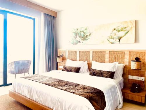 a bedroom with a large bed and a large window at Truntum Boutique Mandalika in Kuta Lombok