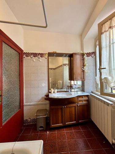 a bathroom with a sink and a large mirror at Casa Al Vicolo - Alley House in Seravezza