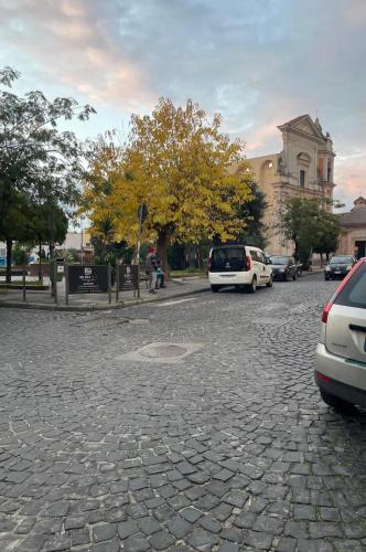 a cobblestone street with cars parked on it at La Casetta Pompei Sorrento Guest House Vesuvio in Boscotrecase