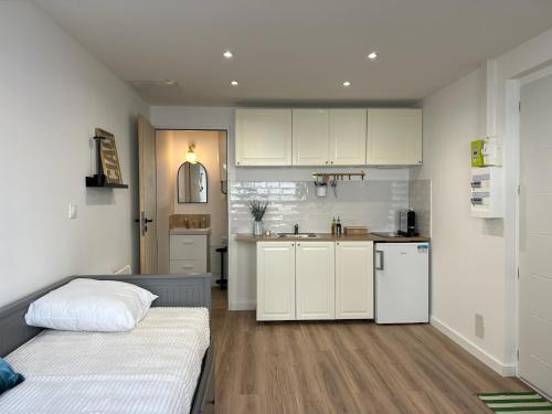 - une cuisine avec des placards blancs et un lit dans une chambre dans l'établissement Studio Moderne & Cosy, à Montpellier