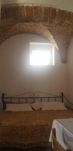 a bedroom with a bed with a window above it at Trullo Chiancola Antica in Alberobello
