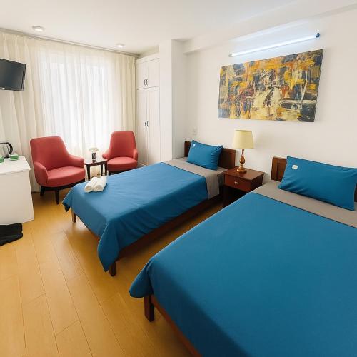 a hotel room with two beds and a chair at Onestar Danang Riverside in Da Nang