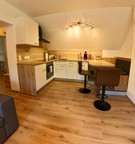 a kitchen with white cabinets and a wooden floor at Ferienwohnungen ARIKOGEL Bad Goisern in Bad Goisern