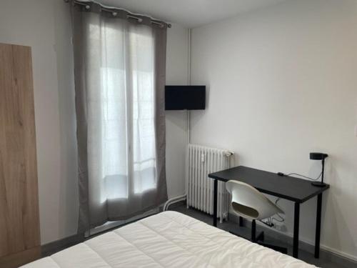- une chambre avec un bureau, un lit, une table et une chaise dans l'établissement T3 Toulon appartement complet, à Toulon
