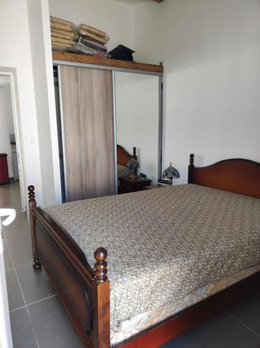 - une chambre avec un lit doté d'un cadre en bois dans l'établissement Maison accueillante à Saintes-Maries-de-la-Mer avec jardin clos, à Saintes-Maries-de-la-Mer