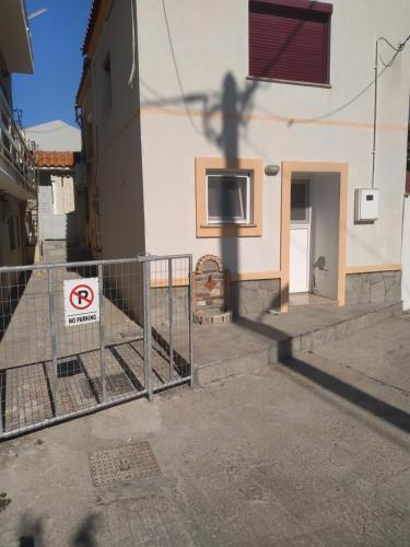 a fence in front of a building with a no parking sign at Charming Town House, Limani 9 in Mirina