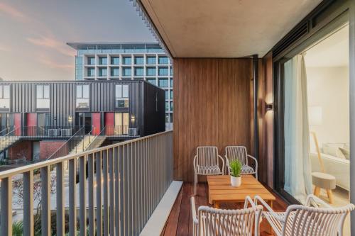 balcón con mesa y sillas de madera en Convenient City Pad - 2BR Laundry Sleeps 5, en Christchurch