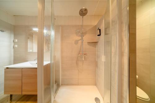 une douche avec une porte vitrée dans une salle de bain dans l'établissement Résidence Les Écureuils, à Gréoux-les-Bains