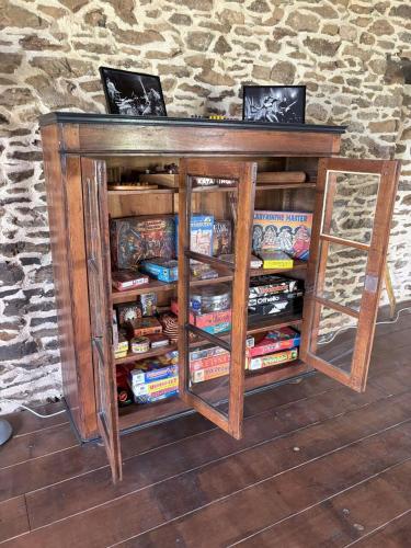 a wooden entertainment center with two glass shelves at Aux 12 instants, Imagine in Lédergues