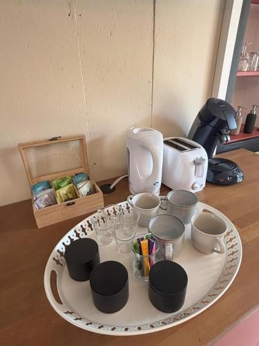 a white plate with cups and bowls on a table at Aux 12 instants, Imagine in Lédergues