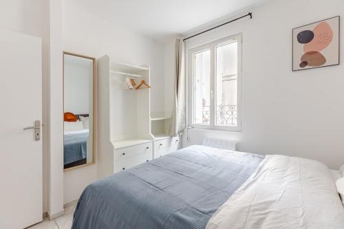 ein weißes Schlafzimmer mit einem Bett und einem Spiegel in der Unterkunft T3 de standing - Porte de Paris - Stade de France in Saint-Denis