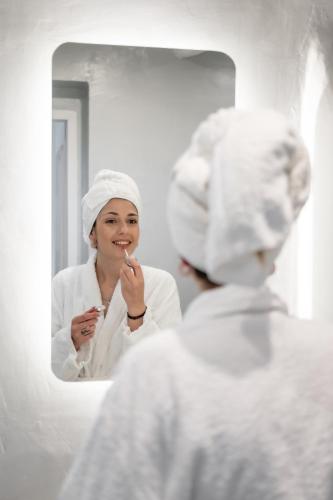 a woman brushing her teeth in front of a mirror at Birbas Hotel in Agia Anna Naxos