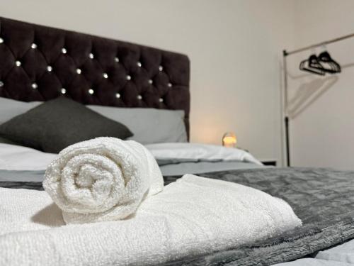 a pile of towels sitting on top of a bed at Cosy King Size Escape - Free Parking in Birmingham