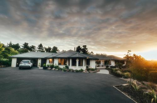 a house with a car parked in a driveway at Kilmarnock House in Dunedin