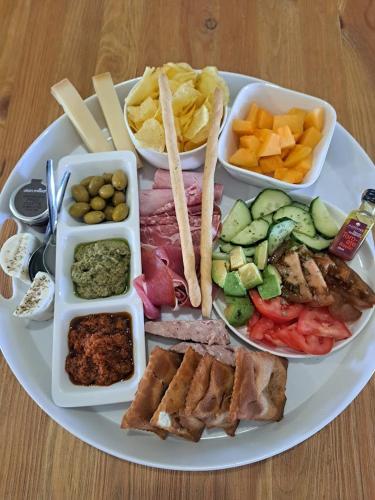 a plate of food with different foods on a table at Hôtel Le Cottage de Sophie in Valernes