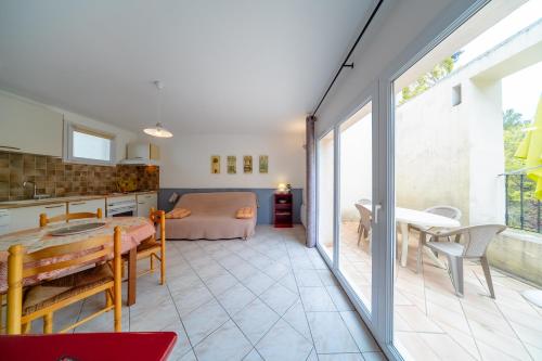 une cuisine et un salon avec une table et un lit dans l'établissement Résidence Les Écureuils, à Gréoux-les-Bains