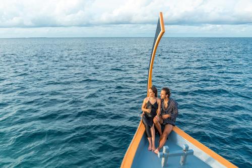 two people sitting on a boat in the water at Lily Beach Resort and Spa - All Inclusive in Dhangethi