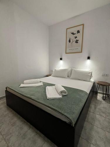 a bedroom with a large bed with towels on it at Liostasi Cottage in Kariotes
