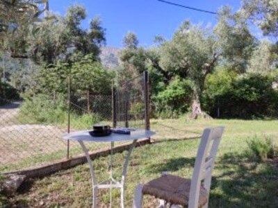 a table and two chairs in a yard at Liostasi Cottage in Kariotes