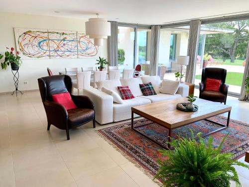 a living room with a white couch and chairs at Villa de Lujo en Campo de Golf - Costa Brava in Peralada
