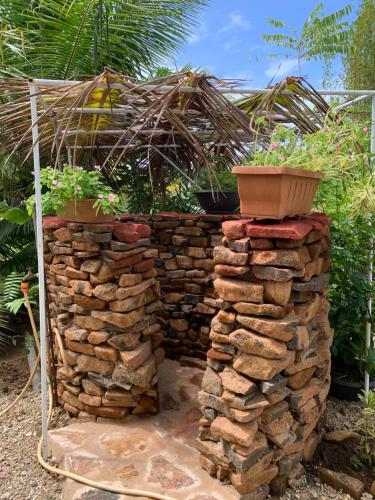 a retaining wall with a pile of rocks and plants at Fare Piti Les pieds dans le lagon in Tiva
