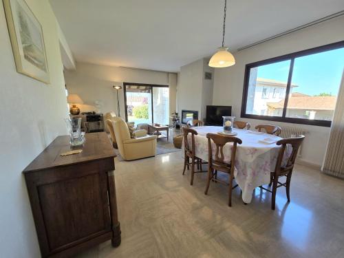 une salle à manger avec une table et des chaises et un salon dans l'établissement Évasion en Ville : Maison avec Piscine Privée, à LʼIsle-dʼEspagnac