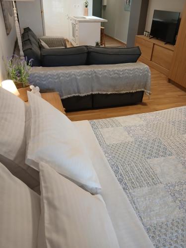a living room with white pillows and a couch at Andromache City Center Cozy Apartment in Rethymno Town