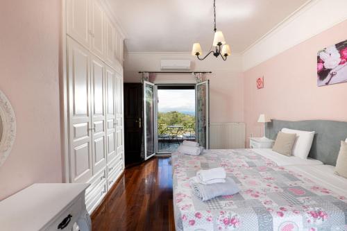 una camera da letto con un letto grande e una grande finestra di Villa Kerkyra a Gouviá