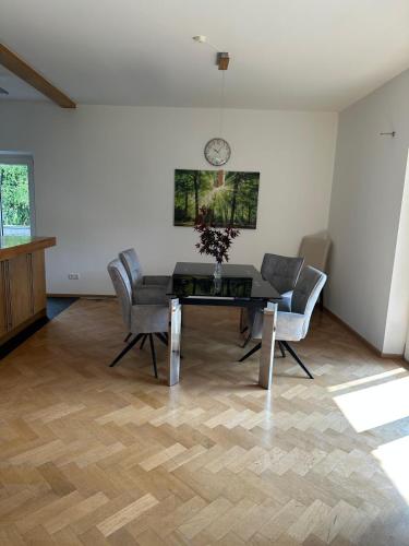 a dining room with a table and chairs and a clock at Landhaus Eugenie in Garmisch-Partenkirchen