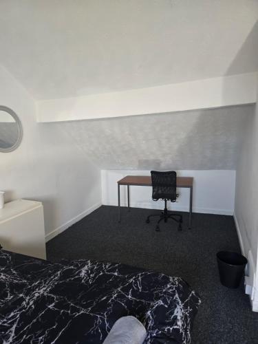 a bedroom with a desk and a bed and a chair at Simple Room Hostel style central Swansea in Swansea