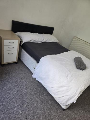a bed in a room with a nightstand and a bed sidx sidx sidx sidx at Simple Room Hostel style central Swansea in Swansea