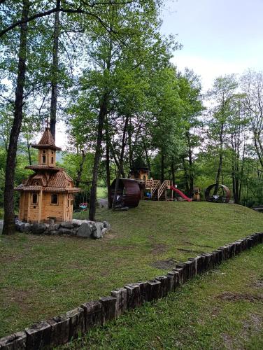 a playground with a wooden house in a park at Dedin Konak in Mokra Gora