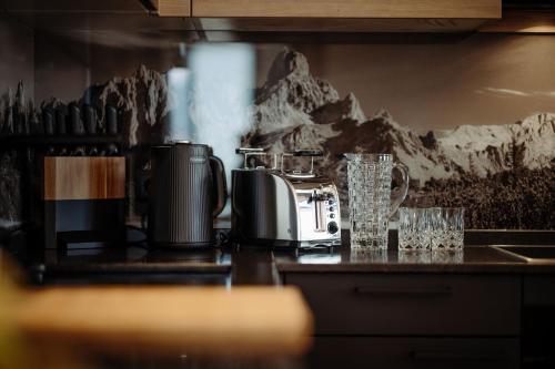 a kitchen counter with a toaster and glasses on it at JUMA alpine living in Flachau