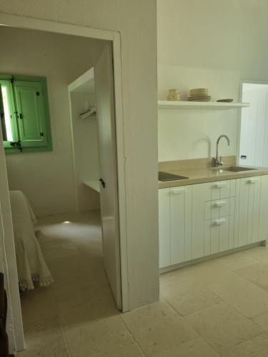 porta aperta a una cucina con lavandino di Agriturismo Le Tagliate a Uggiano la Chiesa