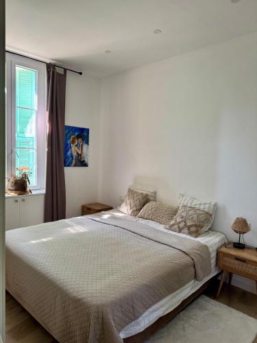 une chambre avec un grand lit et une fenêtre dans l'établissement Aux portes de la Principauté, à Roquebrune-Cap-Martin