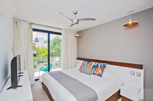 a bedroom with a bed and a tv and a window at Maravilloso Pent House en 5th Avenida nuevo en plataforma in Playa del Carmen