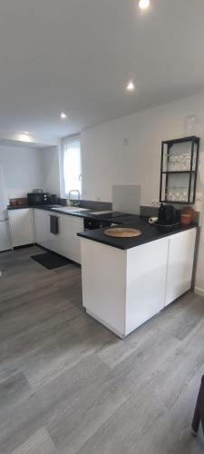 une cuisine avec des armoires blanches et un comptoir noir dans l'établissement Appartement Emplacement Numéro1 Sanary - Plage et port à pied, à Sanary-sur-Mer