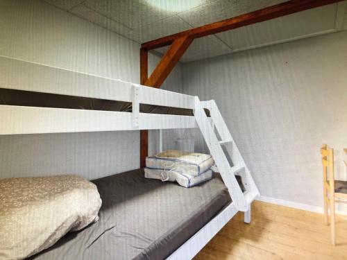 a bedroom with a bunk bed and a ladder at Château de Sus in Løkken